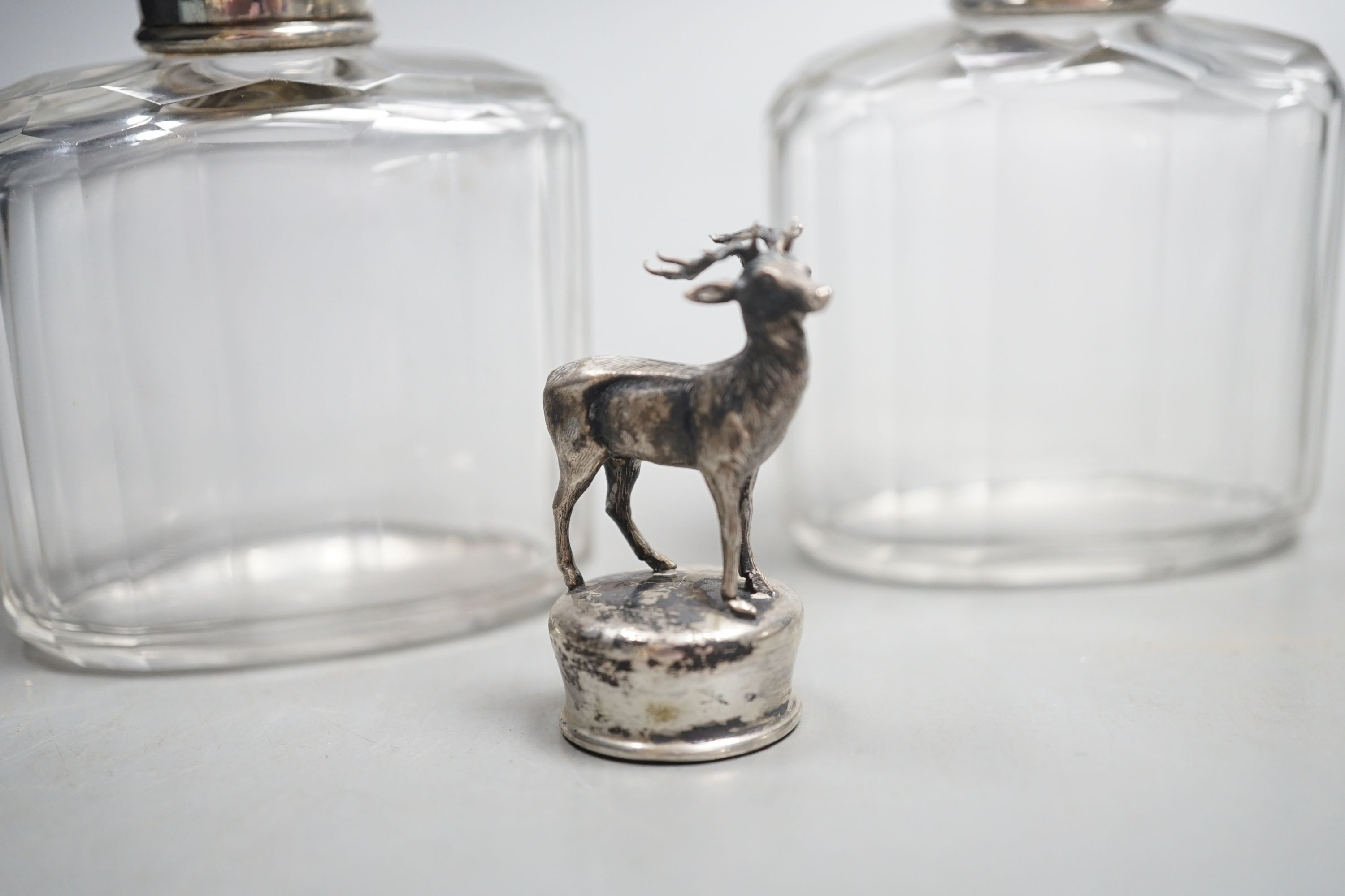 A white metal stag mounted bottle top,48mm, a pair of Edwardian silver topped glass toilet jars and a silver propelling pencil.